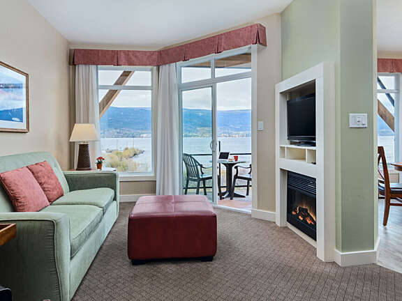 Living and dining area of a two-bedroom suite at Summerland Waterfront Resort with lake views and private balcony